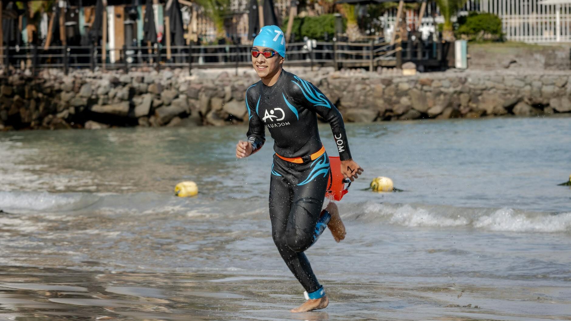 man in swimsuit running on shore in triathlon